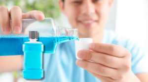 boy pouring mouth wash into dosage cap